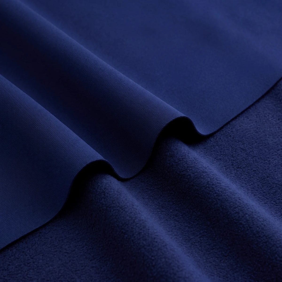 Tela antifluido térmico color azul oscuro: ola mostrando la cara exterior y el perchado interior