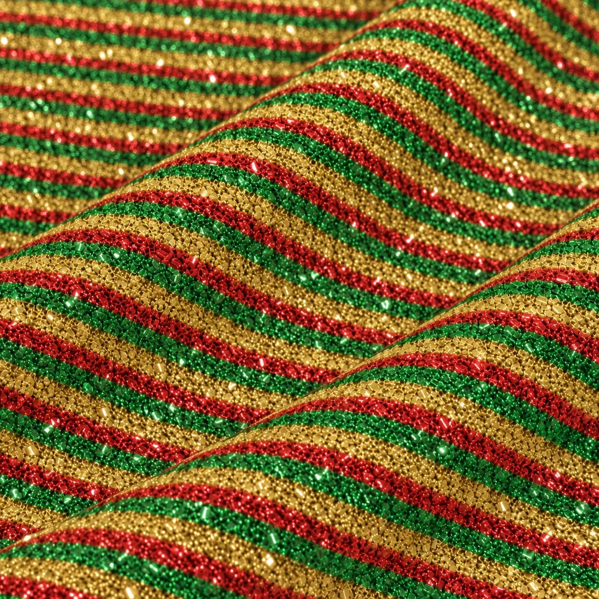 Tela esponjillón tricolor en pliegues ondulados, con detalle de su textura