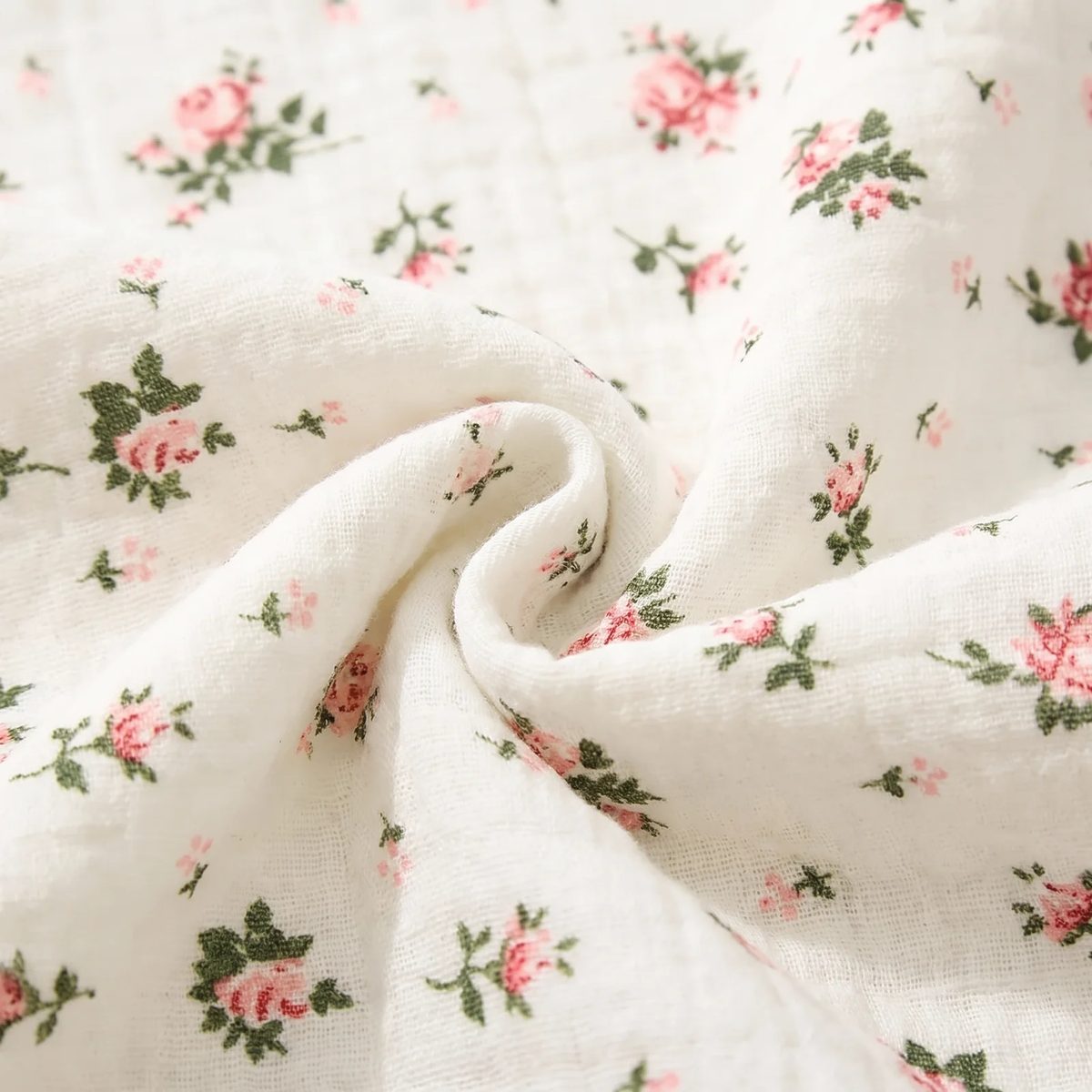 Acercamiento al tejido de la muselina de algodón rojo floral: las dos capas de gasa y su textura arrugada