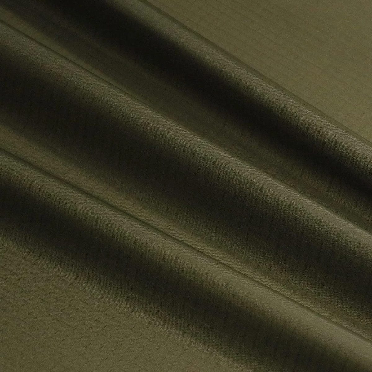 Ripstop de Nylon Impermeable color verde oliva, extendida con pliegues suaves, para ver el color y el brillo