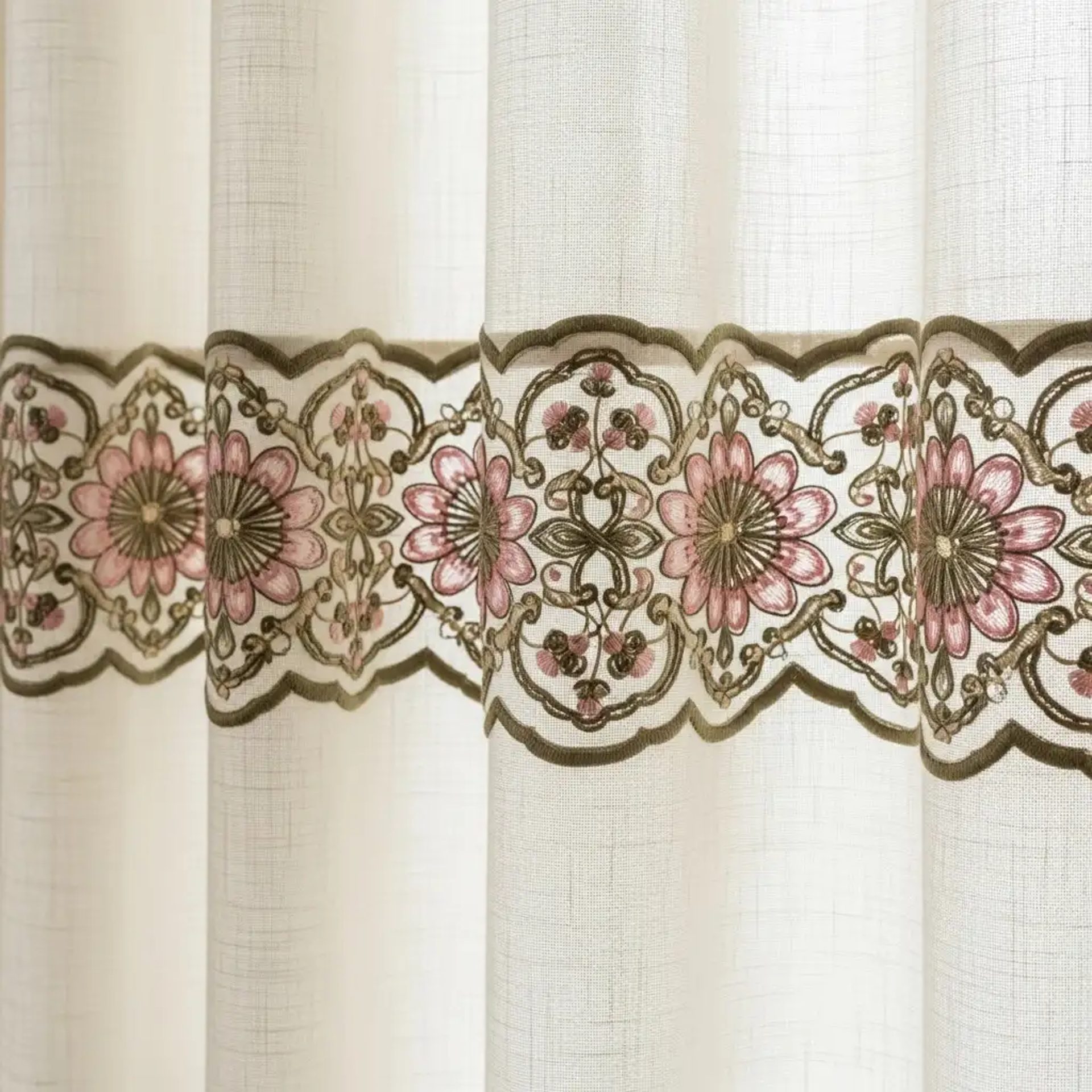 Cenefa bordada con diseño floral en hilos de seda sobre el borde de una cortina de lino crema. Borde decorativo para textiles del hogar.
