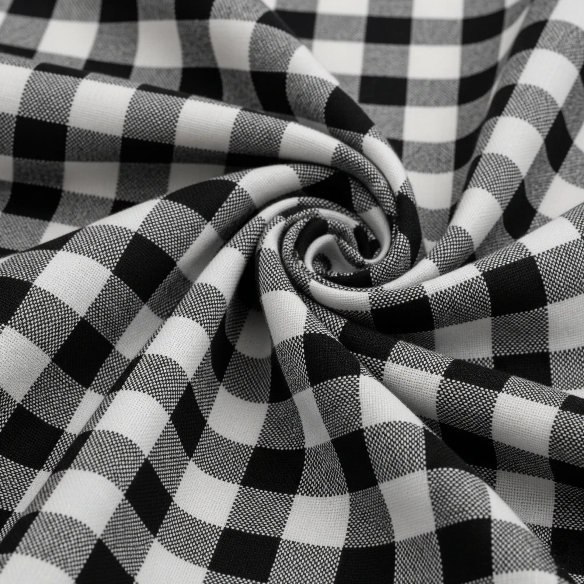 Tela con patrón damero en blanco y negro, mostrando sus característicos cuadros alternos. Patrón geométrico para moda y decoración.