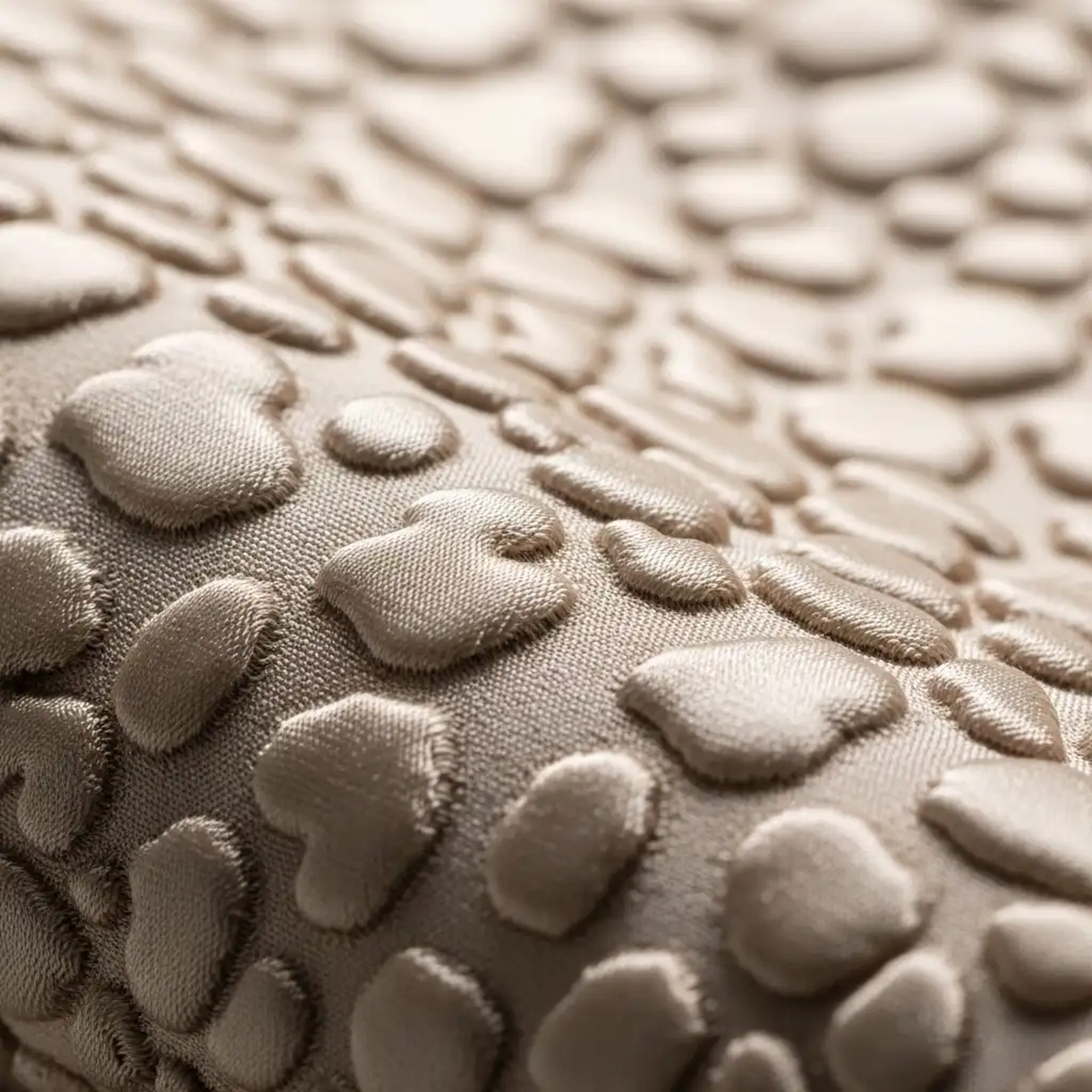 Macro de tejido cloqué color champán, mostrando su característica textura burbujeante y en relieve. Tela de lujo para vestidos y prendas estructuradas.