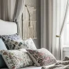 Habitación elegantemente decorada con diversos elementos textiles como cojines, cortinas y cabecero tapizado, mostrando ideas para decorar con telas.