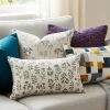 Sofá moderno renovado con una variedad de cojines decorativos hechos con las mejores telas, mostrando diferentes texturas y colores.